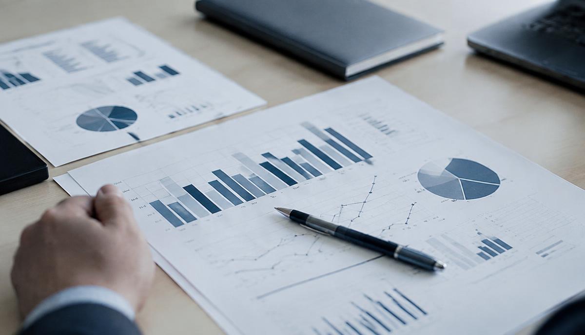 Printed performance charts and a pen on a desk being reviewed
